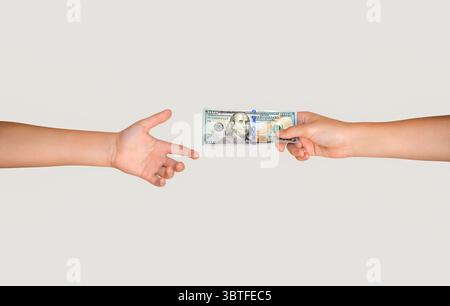 Handling 100 dollar bill of cash to other hand. Man giving dollar banknotes to woman. Male hand holding 100 dollar cash bills passing it on to another Stock Photo