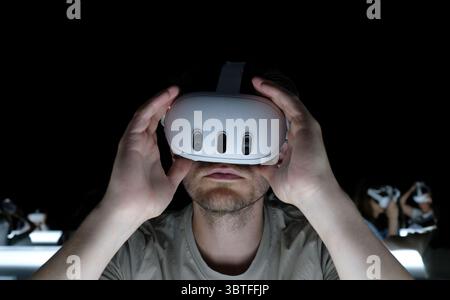Man wearing virtual reality headset in a dark room Stock Photo