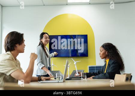 Diverse coworkers pointing at turbine graphics on screen and discussing models in meeting room Stock Photo