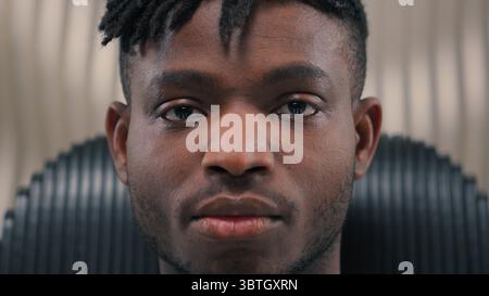 Close up portrait African American ethnic man male guy serious mood unsmiling confident emotion headset in futuristic studio futurism room looking at Stock Photo