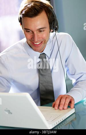 Businessman using headset at work Stock Photo