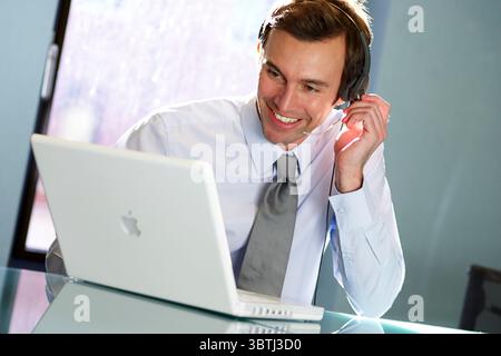 Businessman using headset at work Stock Photo