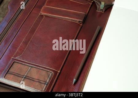 A sophisticated leather portfolio displays various compartments and a pen. Stock Photo