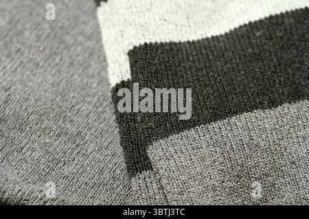 Warm and inviting knitted fabric showcases a blend of gray and green hues. Stock Photo