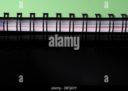 Cover edge of a spiral notepad for notes on a black mirrored background ...