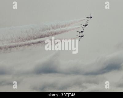 The United States Air Force Thunderbirds fly in tight diamond formation through overcast skies during an airshow performance at McGuire Air Force Base Stock Photo