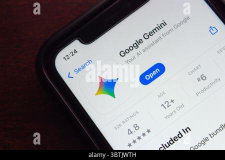 Smartphone screen showing Google Gemini app listing in the App Store, including rating, age info, and productivity ranking. Stock Photo