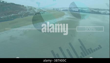Displaying interface overlay over snowy beach with pie charts, bar graphs and 100% progress bar Stock Photo