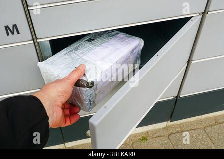 Removing or placing a package in an outdoor automated locker system locker, highlighting modern delivery convenience Stock Photo