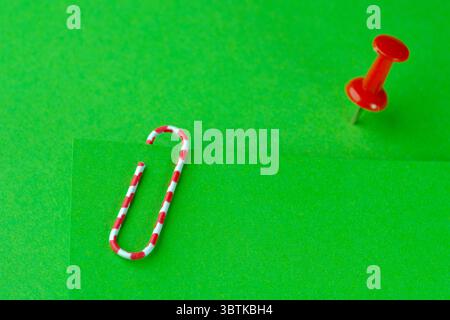Red paperclip and red button on green blank sheets Stock Photo