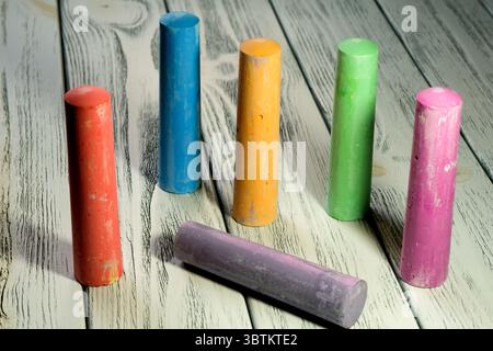 Colored crayons for drawing on a white wooden table in twilight light stationery educational background Stock Photo