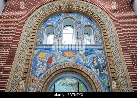 John Joseph Earley's Historic Mosaic Arch in Smithsonian National Zoo Bird House in Washington DC | WASHINGTON, D.C., United States — Tropical birds and floral vines in polychrome concrete mosaic surround the arched entrance of the Bird House at the Smithsonian National Zoo, created by John Joseph Earley for the building's 1928 opening. Earley's exposed-aggregate process embedded colored stone into cement to create fade-resistant imagery without paint or glaze. Following the Bird House's renovation, completed in 2023, the arch was preserved and now stands within the building's interior lobby. Stock Photo
