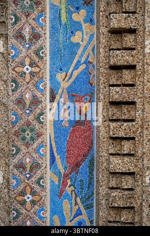 John Joseph Earley's Historic Mosaic Arch in Smithsonian National Zoo Bird House in Washington DC | WASHINGTON, D.C., United States — A crested red bird rendered in polychrome concrete perches among golden branches in this detail of the Bird House mosaic at the Smithsonian National Zoo, created by John Joseph Earley for the building's 1928 entrance. The adjacent diamond-patterned border and ribbed pilaster show the range of decorative and structural forms achieved with Earley's exposed-aggregate concrete process. The mosaic survives from the Zoo's 1920s modernization under architect Albert L.  Stock Photo