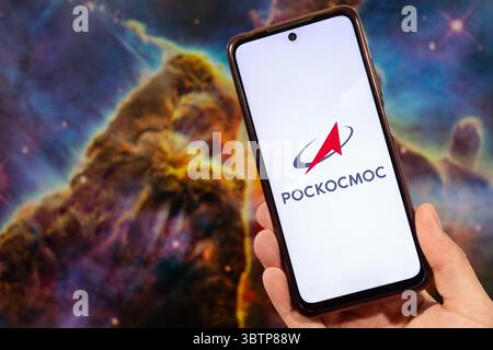 BOGOTA, COLOMBIA - JULY 14 OF 2025 A male hand holding a smartphone with Roscosmos logo in russian with blurred space image at background Stock Photo
