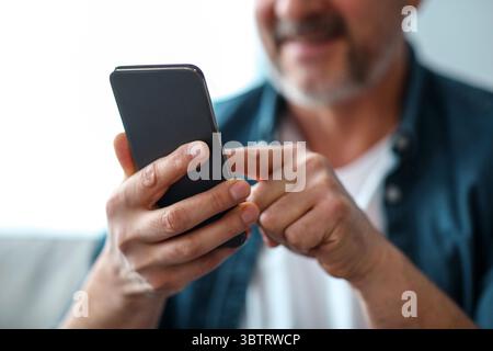 Unrecognizable matured man using modern mobile phone Stock Photo