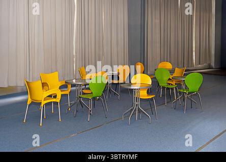 Retro colorful plastic chairs and tables inside empty cafe interior Stock Photo