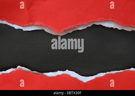 Ripped red paper on black background Stock Photo