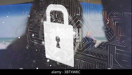 Displaying white padlock icon hovering over circuit board overlay at office desk, with monitors Stock Photo