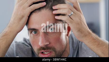 Portrait, man and checking hairline, worry or concerned for hair loss in house, self care and scalp. Home, grooming and inspection for thinning Stock Photo