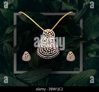 Stylish Diamond Pendant and Earring Set with Gold Chain on Leafy Green Background Stock Photo