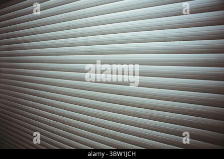 Metal rolling shutter door is being shown in flat design, highlighting repeating horizontal slats Stock Photo