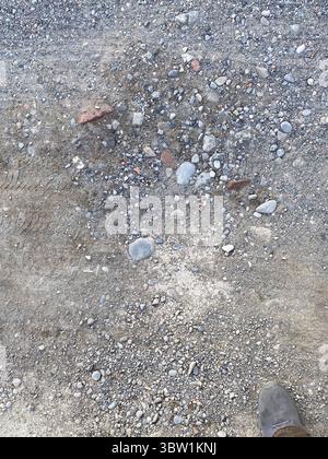 Gravel and Sand Texture Abstract Close Up With Small Pebbles and Light Scattered Throughout Creating a Rough Ground Surface Suitable for Natural Backd Stock Photo