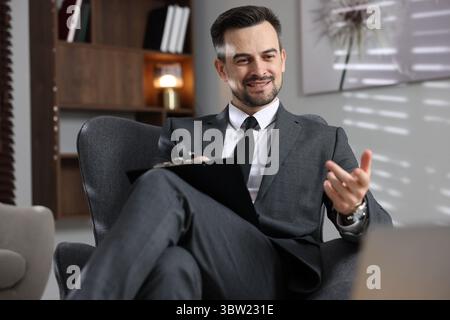 Professional psychologist having online consultation with his client via laptop indoors Stock Photo