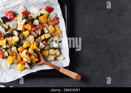 Roasted vegetabes on black slate background Stock Photo