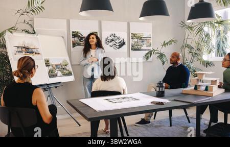 A team of professionals discussing and sharing ideas for an architectural project in a contemporary styled meeting room with various visual aids, fost Stock Photo