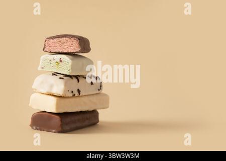 Different whey protein bars with various coatings and sprinkles on beige background. Close up. Copy space. Stock Photo