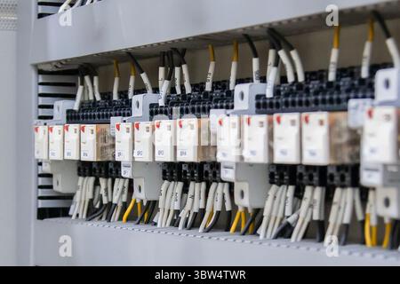 Electrical engineers use multimeters to check electrical installations and current flow in electrical control cabinets. Stock Photo