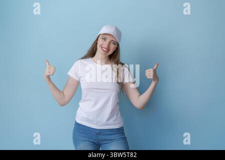 Hey look. Smiling beautiful female model pointing her fingers to an empty space Stock Photo