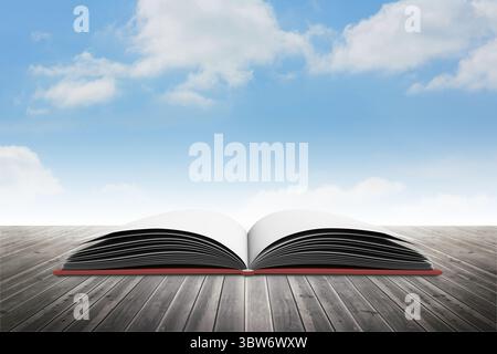flat design open book with blank pages is lying on wooden deck under sky with clouds Stock Photo