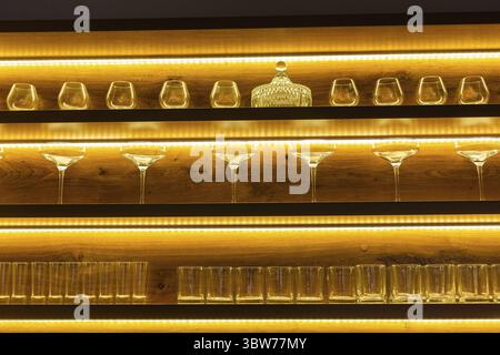 Glasses of wine. Glasses hanging above the bar in the restaurant. Empty glasses for wine. Wine and martini glasses in shelf above a bar rack in restau Stock Photo