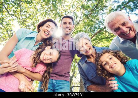 Low angle view of happy caucasian multi-generation family looking at camera while enjoying in park Stock Photo