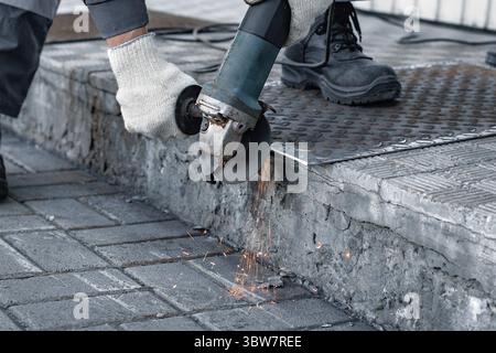 Processing of metal sheet with an angle-grinding tool. Production and industrial background Stock Photo