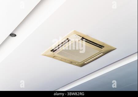Old cassette type air conditioner on ceiling indoor. Electronics and purifier concept Stock Photo