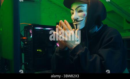Lviv, Ukraine - June 03, 2024: Hacker man anonymous dangerous computer pc criminal stealing information online datum hooded mysterious person coding Stock Photo