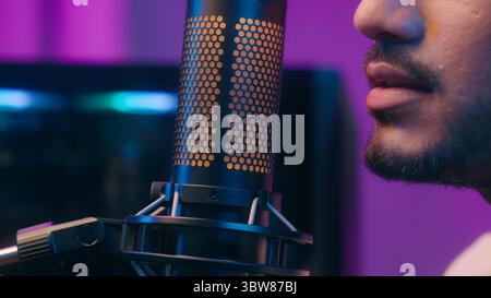 Arabian Latino Indian man holding microphone mic record podcast sound prepare for streaming streamer player gamer computer influencer blogger online Stock Photo