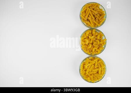 Various types of raw pasta in different containers in an isolated shot, with copy space on a white background Stock Photo