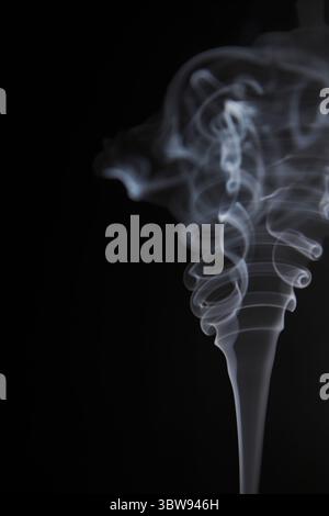 Abstract figure created by white smoke on an isolated black background to stimulate the subconscious with truly beautiful shapes Stock Photo