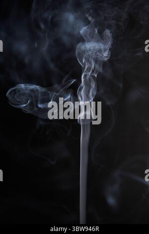 Abstract figure created by white smoke on an isolated black background to stimulate the subconscious with truly beautiful shapes Stock Photo