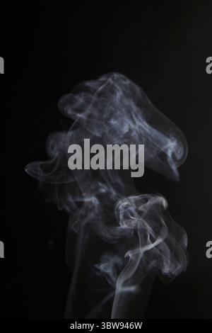 Abstract figure created by white smoke on an isolated black background to stimulate the subconscious with truly beautiful shapes Stock Photo