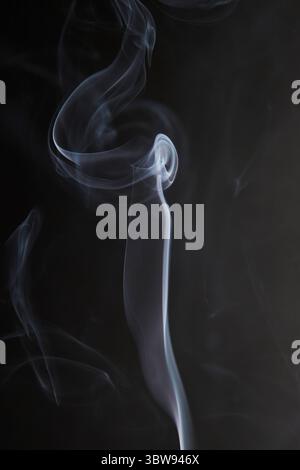 Abstract figure created by white smoke on an isolated black background to stimulate the subconscious with truly beautiful shapes Stock Photo