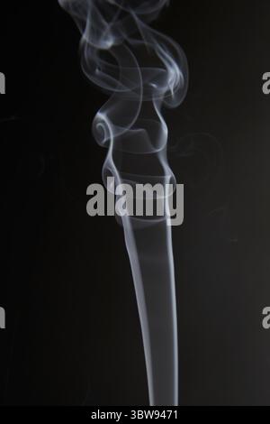 Abstract figure created by white smoke on an isolated black background to stimulate the subconscious with truly beautiful shapes Stock Photo