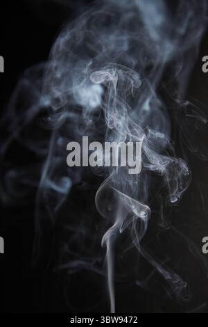 Abstract figure created by white smoke on an isolated black background to stimulate the subconscious with truly beautiful shapes Stock Photo