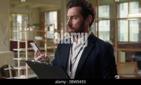 Angry man business employer annoyed businessman guy talking mobile phone in office male director entrepreneur middle-aged irritated mad quarrel Stock Photo