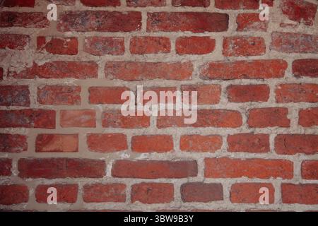 Background texture of uneven red brick masonry, aged and weathered Stock Photo