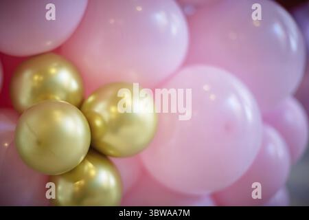 Many pink and gold balloons forming a bright background wallpaper image. close-up Stock Photo