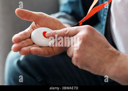 Man pushing panic button on emergency equipment for elderly people Stock Photo